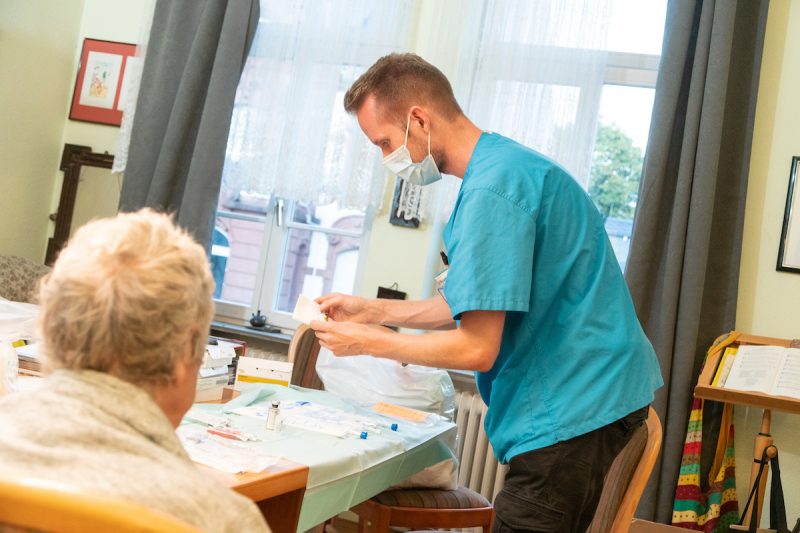 Pfleger gibt Patientin Medikamente